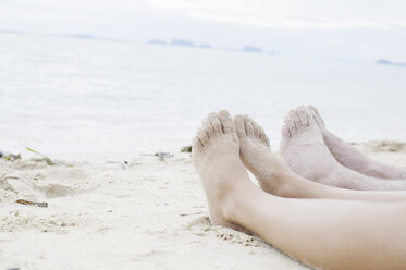 Young couples legs on beach, Kradan, Thailand - CUF23962