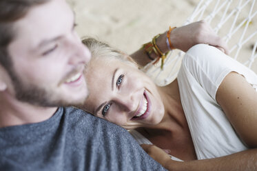 Nahaufnahme eines lächelnden jungen Paares in einer Hängematte am Strand - CUF23971