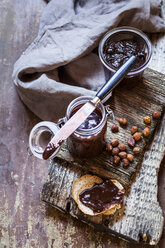 Glass of homemade chocolate spread, hazelnuts and bread slices - SBDF03589