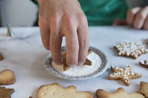 Männerhand beim Verzieren von Weihnachtsplätzchen, Nahaufnahme - SKCF00487