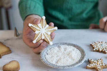 Mann hält selbstgebackene Weihnachtsplätzchen in der Hand, Nahaufnahme - SKCF00488