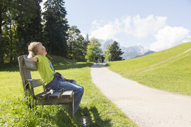 Junge sitzt auf einer Parkbank am Straßenrand, Eckbauer bei Garmisch, Bayern, Deutschland - CUF24008