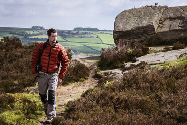 Junger Mann beim Wandern auf dem Krokodilfelsen, Pateley Bridge, Nidderdale, Yorkshire Dales - CUF24045