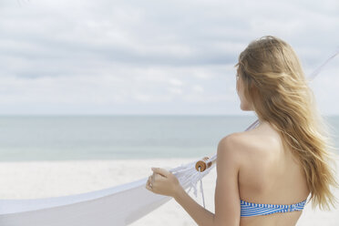 Junge blonde Frau mit Blick auf das Meer von Miami Beach, Florida, USA - CUF24063