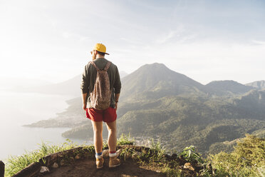 Rear view of young man looking out over Lake Atitlan, Guatemala - CUF24078