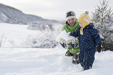 Vater und Sohn spielen im Schnee - CUF24118