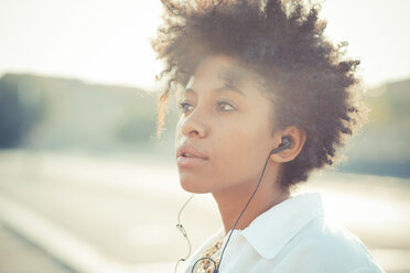 Porträt einer nachdenklichen jungen Frau mit Kopfhörern - CUF24143