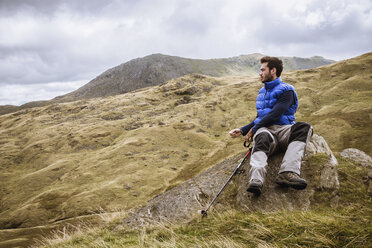 Junger männlicher Wanderer mit Blick auf die Landschaft, The Lake District, Cumbria, UK - CUF24170