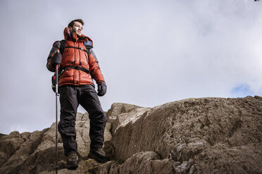 Junger männlicher Wanderer, der aus den Felsen schaut, The Lake District, Cumbria, UK - CUF24183