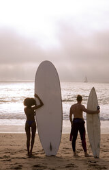 Rear view of young surfing couple looking out to sea, Playa Del Rey, California, USA - CUF24184