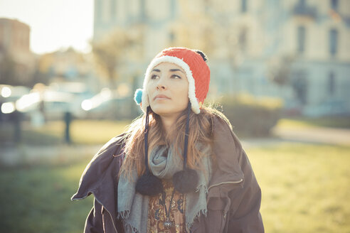 Mittlere erwachsene Frau mit roter Pom-Pom-Mütze im Park - CUF24269