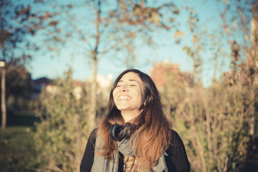 Mittlere erwachsene Frau lachend mit geschlossenen Augen im Park - CUF24271