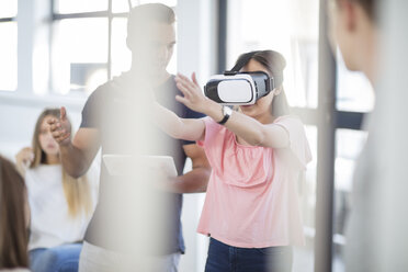 Teacher with tablet student wearing VR glasses in class - ZEF15704