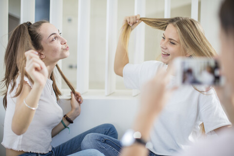 Teenage girl taking cell phone picture of her happy friends stock photo