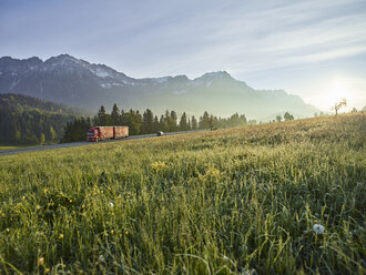 Österreich, Tirol, LKW auf Landstraße im Morgenlicht - CVF00733