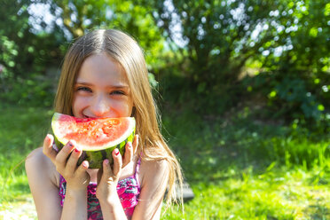 Porträt eines lächelnden Mädchens, das im Sommer eine Wassermelone isst - SARF03770