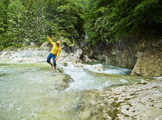 Österreich, Tirol, Brandenberg, Mann überquert Brandenberger Ache, Spritzwasser - CVF00735