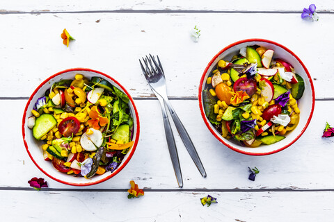 Zwei Schalen mit gemischtem Salat und essbaren Blumen, lizenzfreies Stockfoto