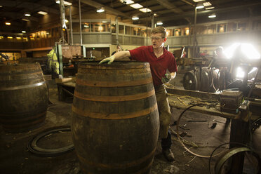 Erwachsener Mann bei der Herstellung eines Whiskyfasses in einer Küferei - CUF24519