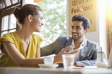 Young couple sitting inside cafe, talking, low angle view - CUF24535