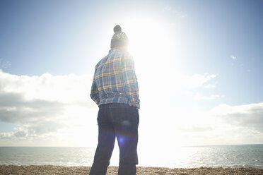Mature man looking out to sea from beach - CUF24749