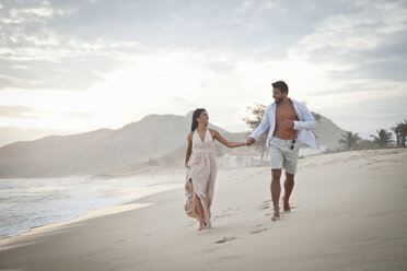 Mid adult couple walking along beach, hand in hand - CUF24767