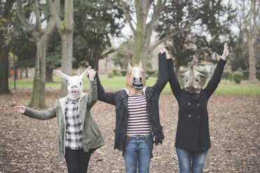 Drei Schwestern mit Tiermasken tanzen im Park - CUF24854