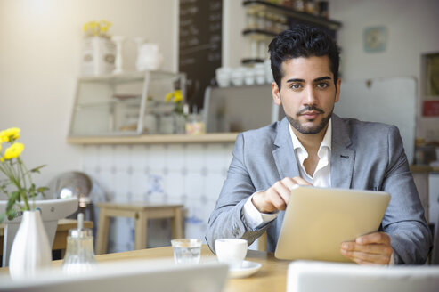 Mann benutzt digitales Tablet in einem Cafe - CUF24930