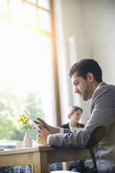 Mann benutzt digitales Tablet in einem Cafe - CUF24931
