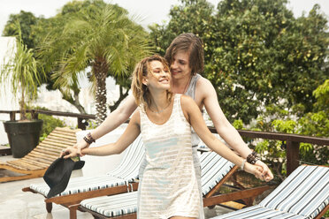 Young couple holding hands at hotel poolside, Rio De Janeiro, Brazil - CUF24962