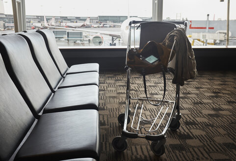 Smartphone in shoulder bag in luggage trolley in airport lounge - ISF09375