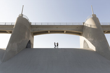 Händchenhaltendes Paar unter einer Brücke, Van Nuys, Kalifornien, USA - ISF09405