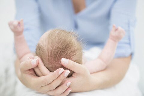 Mutter wiegt Baby in den Armen, lizenzfreies Stockfoto