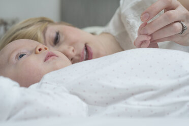 Mother with baby girl on bed - CUF25143