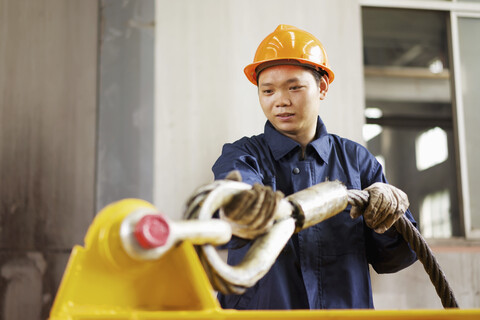 Arbeiter bei der Verwendung von Ausrüstung in einer Kranfabrik, China, lizenzfreies Stockfoto