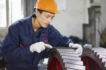 Worker using equipment in crane manufacturing facility, China - CUF25240