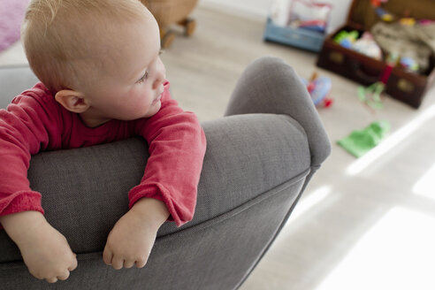 Babymädchen im Wohnzimmer auf dem Sofa liegend - CUF25255