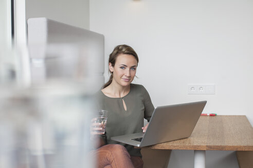 Porträt einer jungen Frau mit Laptop im Büro - CUF25320