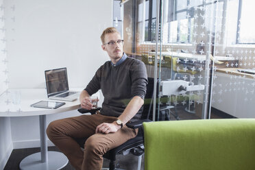 Young man gazing from office desk - CUF25326