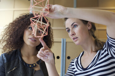 Zwei junge Designerinnen betrachten ein handgefertigtes Modell im Kreativbüro - CUF25350