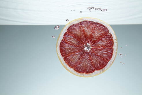 Scheibe einer rosa Grapefruit unter Wasser - CUF25574