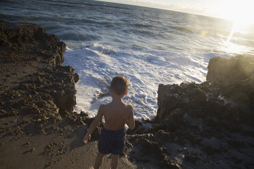 Rückansicht eines Jungen, der die Meereswellen beobachtet, Blowing Rocks Preserve, Jupiter Island, Florida, USA - ISF09434