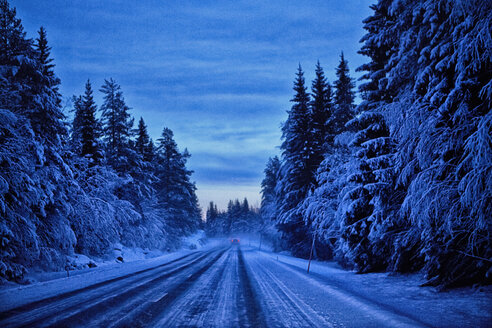 Leere schneebedeckte Straße in der Abenddämmerung, Hemavan, Schweden - CUF25784