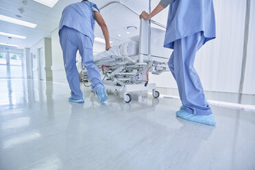 Zwei Sanitäter schieben dringend ein Krankenhausbett im Flur - CUF25801