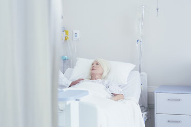 Arzt im Gespräch mit besorgter älterer Patientin im Krankenhausbett - CUF25807