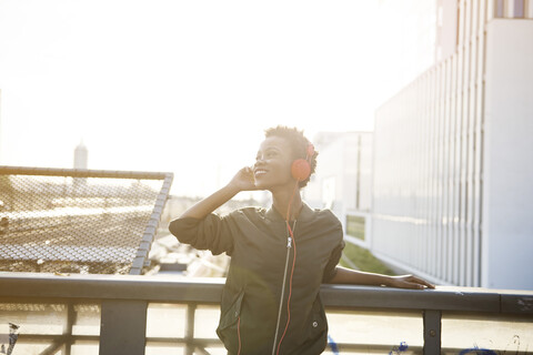 Portrait of smiling young woman listening music with headphones stock photo