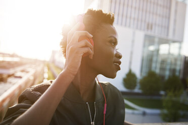 Young woman at backlight listening music with headphones - ABIF00584