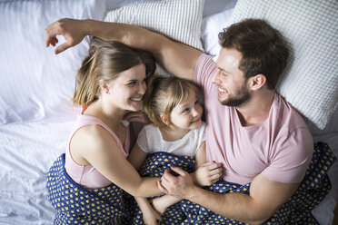 Glückliche Familie im Bett liegend, kuschelnd - AWF00005