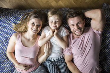 Glückliche Familie im Bett liegend, kuschelnd - AWF00006