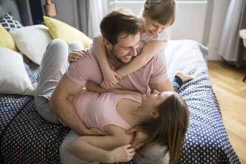 Glückliche Familie im Bett liegend, kuschelnd - AWF00012